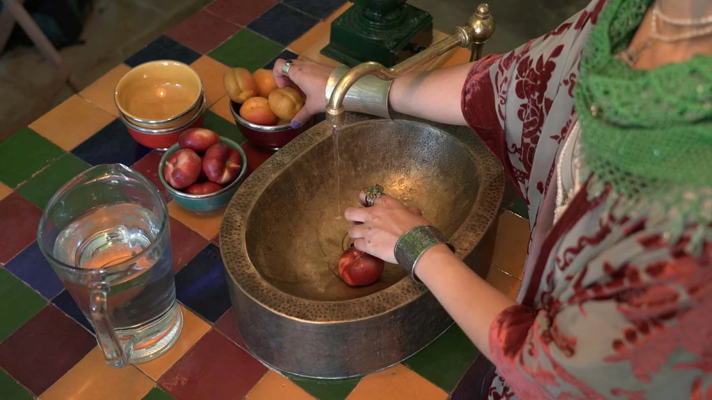 Preparing pomegranates at a brass basin